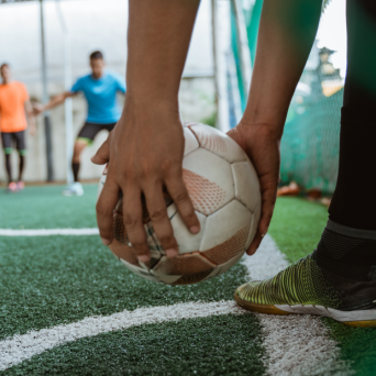 duas-maos-de-jogador-segurando-a-bola-dando-um-escanteio 1